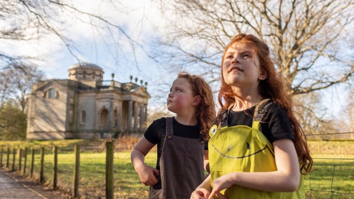 Close up of two children in dungarees in front of Gibside Chapel.